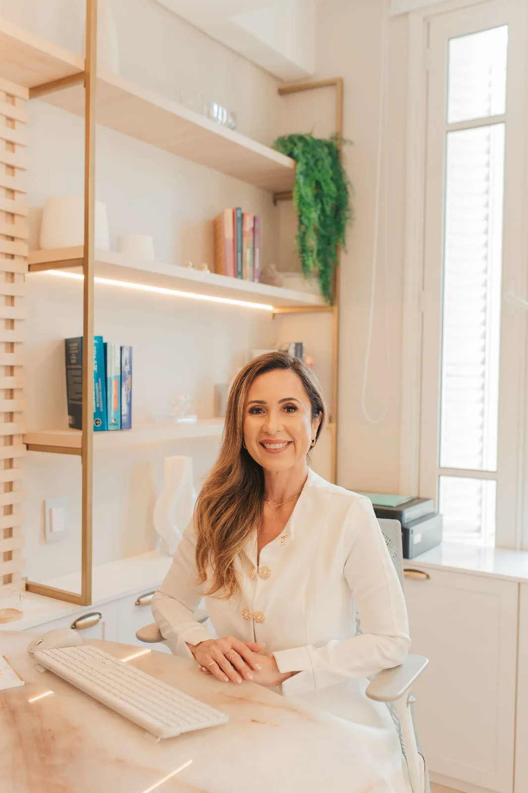 Andréa Cavalcanti sentada à mesa do consultório